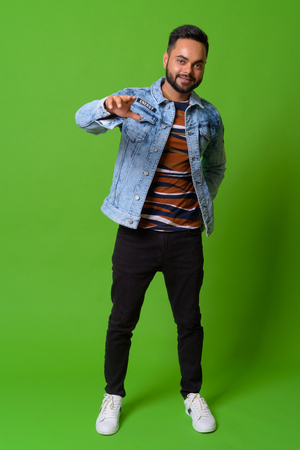 Young bearded Indian man against green backgroundの写真素材