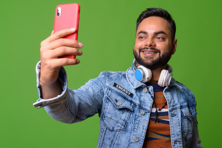 Young bearded Indian man against green backgroundの写真素材