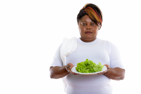 Studio shot of fat black African woman holding lettuce served onの写真素材