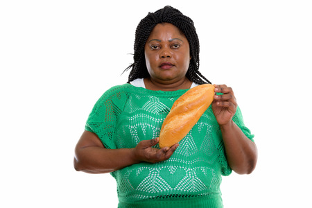 Studio shot of fat black African woman holding breadの写真素材