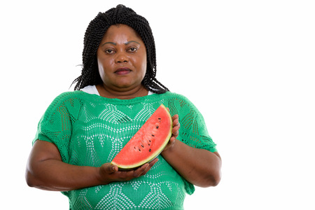 Studio shot of fat black African woman holding slice of watermelの写真素材