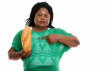 Studio shot of fat black African woman holding and pointing at bの写真素材
