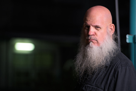 Portrait Of Bald Man With Gray Beard Outdoors At Night