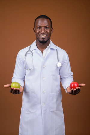 Handsome African man doctor against brown backgroundの写真素材