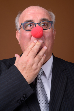 Overweight senior businessman wearing red clown noseの写真素材