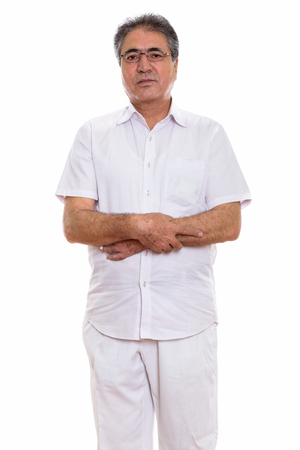 Studio shot of senior Persian man standing with arms crossedの写真素材