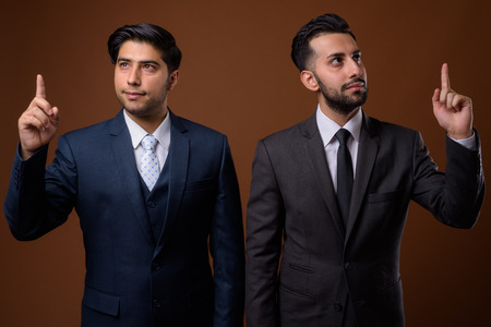 Studio shot of young handsome Iranian brothers together againstの写真素材