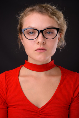 Young beautiful woman with blond curly hair against gray backgroの写真素材