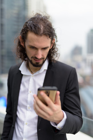 Handsome businessman against view of the city in Bangkok, Thailaの写真素材