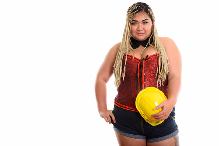 Young fat Asian construction woman holding safety helmet while p