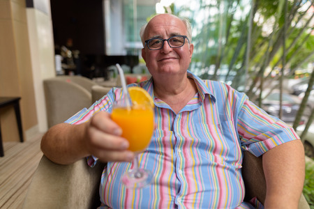 Overweight senior tourist man exploring around the city of Bangkの写真素材