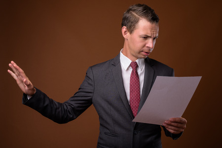 Studio shot of businessman against brown backgroundの写真素材