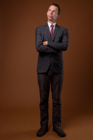 Studio shot of businessman against brown backgroundの写真素材