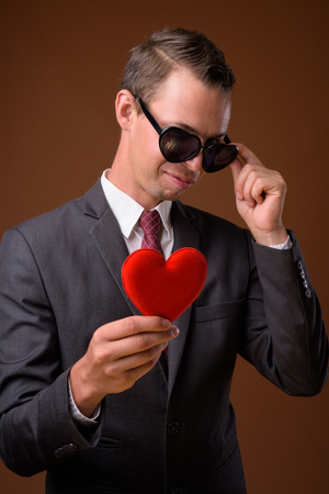 Studio shot of businessman against brown backgroundの写真素材