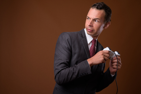 Studio shot of businessman against brown backgroundの写真素材