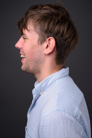 Studio shot of young handsome man against gray backgroundの写真素材