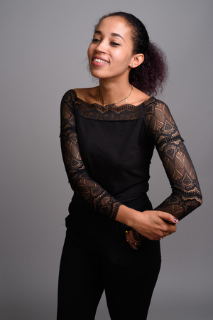 Young beautiful African woman against gray backgroundの写真素材