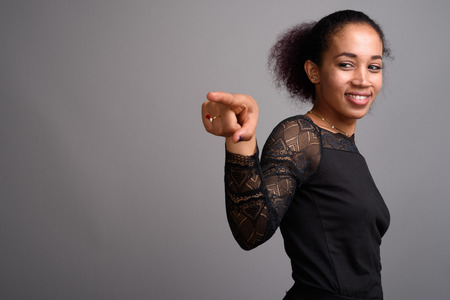 Young beautiful African woman against gray backgroundの写真素材