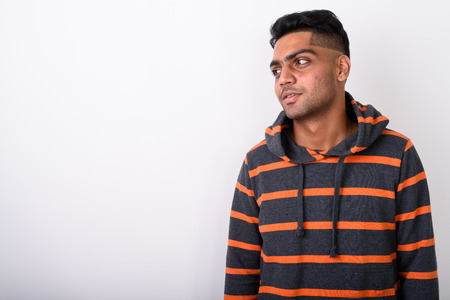 Young Indian man wearing hoodie against white backgroundの写真素材