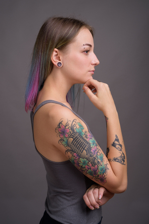 Young beautiful rebellious woman with multicolored hair againstの写真素材