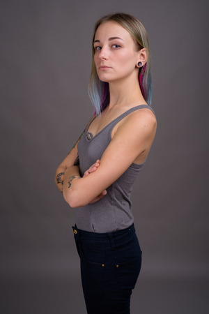 Young beautiful rebellious woman with multicolored hair againstの写真素材