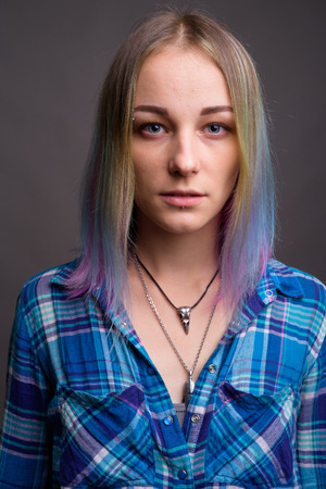 Young beautiful rebellious woman with multicolored hair againstの写真素材