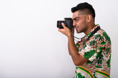Young Indian tourist man wearing Hawaiian shirt against white baの写真素材