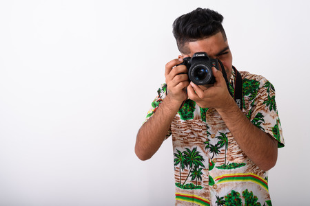 Young Indian tourist man wearing Hawaiian shirt against white baの写真素材