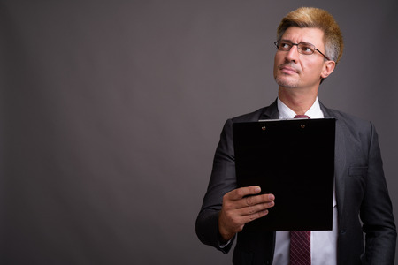 Businessman with blond hair against gray backgroundの写真素材
