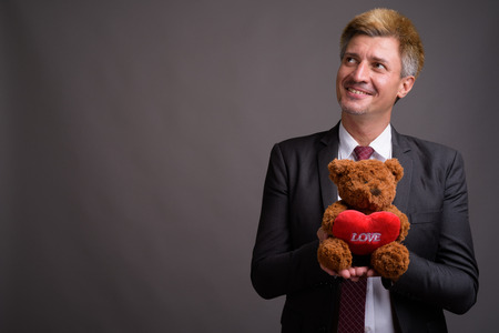 Businessman with blond hair against gray backgroundの写真素材