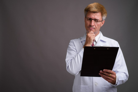 Man doctor with blond hair against gray backgroundの写真素材