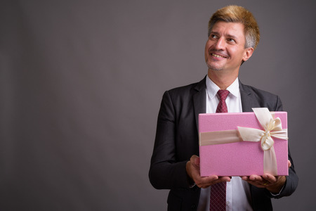 Businessman with blond hair against gray backgroundの写真素材