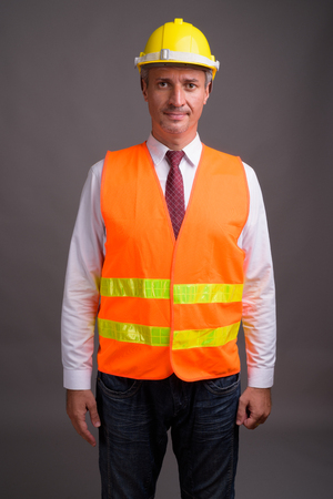 Portrait of man construction worker against gray backgroundの写真素材