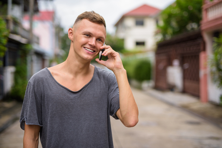 Young man using mobile phone in the streets outdoorsの写真素材