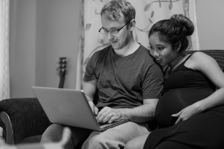 Multi-ethnic couple married and in love in the living roomの写真素材