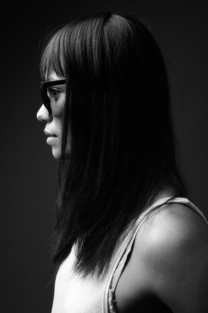 Young Asian woman against gray background in black and whiteの写真素材