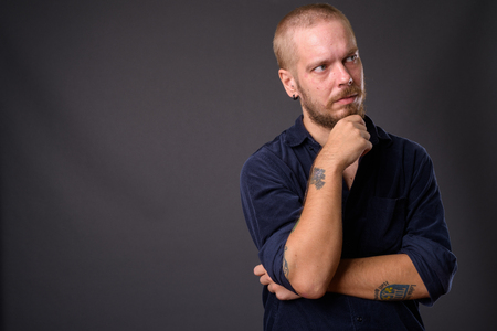 Portrait of man against gray studio backgroundの写真素材