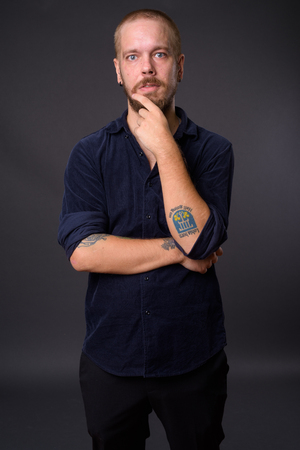 Portrait of man against gray studio backgroundの写真素材