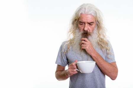 Studio shot of stressed senior bearded man thinking while holdinの写真素材