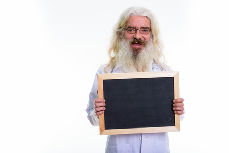 Studio shot of happy senior bearded man doctor smiling while hol