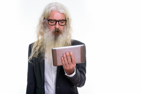 Studio shot of senior bearded businessman using digital tabletの写真素材