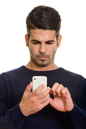 Face of young handsome Persian man using mobile phone touching tの写真素材