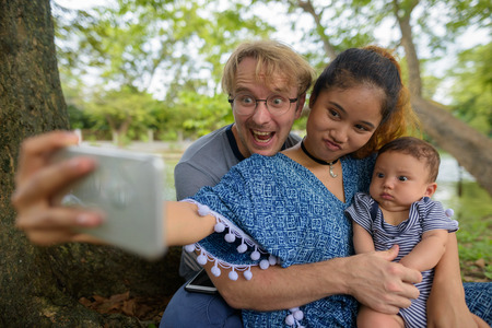 Multi-ethnic young family bonding together at the parkの写真素材