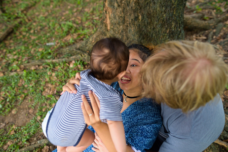 Multi-ethnic young family bonding together at the parkの写真素材