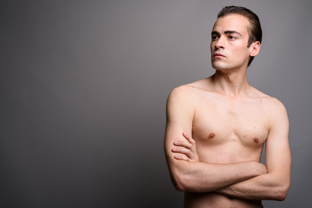 Young handsome man shirtless with arms crossed thinkingの写真素材