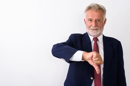 Studio shot of handsome senior bearded businessman giving thumbの写真素材