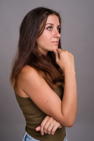 Portrait of young beautiful woman against gray backgroundの写真素材