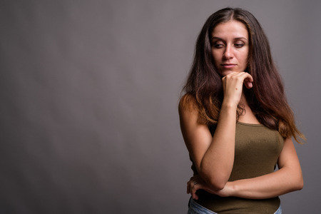 Portrait of young beautiful woman against gray background