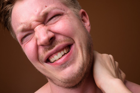 Face of young man having neck painの写真素材
