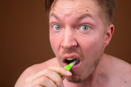 Face of young man brushing his teethの写真素材
